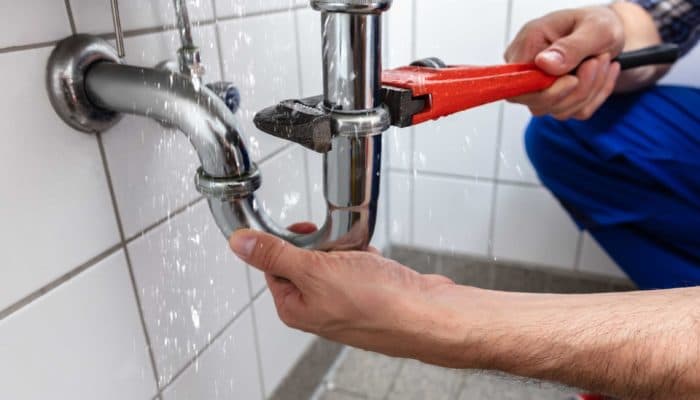 Primo piano di una goccia d'acqua che cade da un rubinetto che perde.